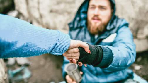 Unhoused man reaching for a hand